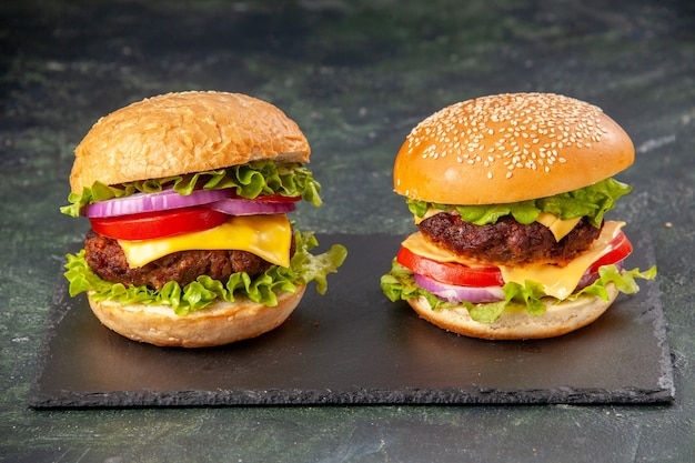 Leckere Sandwiches auf schwarzer Tafel auf dunkler Mischfarbe