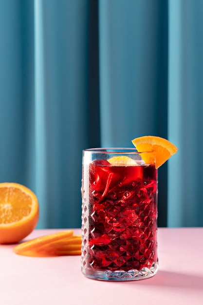 Leckere Sangria mit Orangenscheiben auf rosafarbenem Tisch