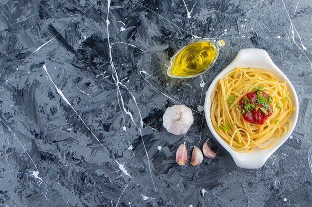 Leckere Spaghetti auf weißem Teller mit Tomatensauce und Olivenöl.