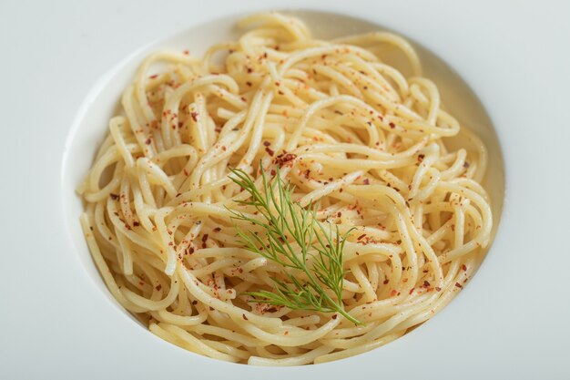 Leckere Spaghetti mit Gemüse auf einem weißen Teller.