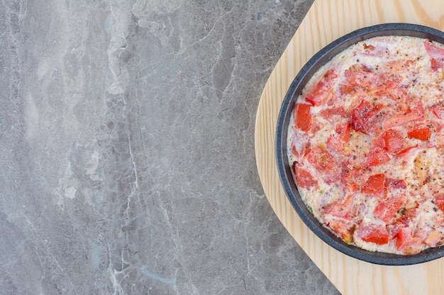 Leckere Spiegeleier mit Tomaten auf dunkler Pfanne. Foto in hoher Qualität