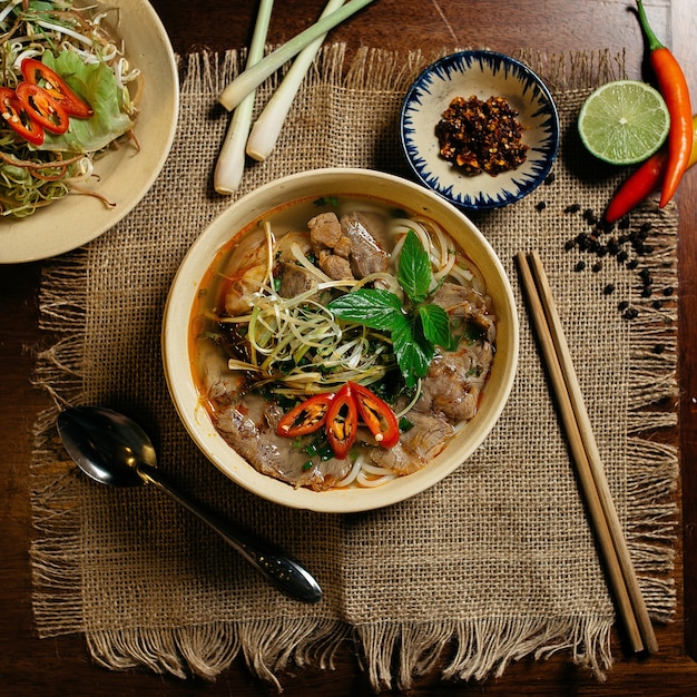 Leckere Suppe mit Fleisch und Nudeln in einer weißen Schüssel