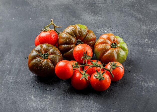 Leckere Tomaten auf grungy grauer Wand, hohe Winkelansicht.