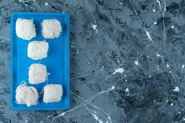 Leckere türkische Zuckerwatte auf einer Holzplatte, auf dem blauen Tisch.