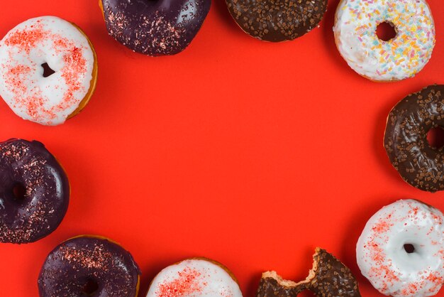 Leckere verschiedene Schokolade gebissene Donuts mit bunten Streuseln