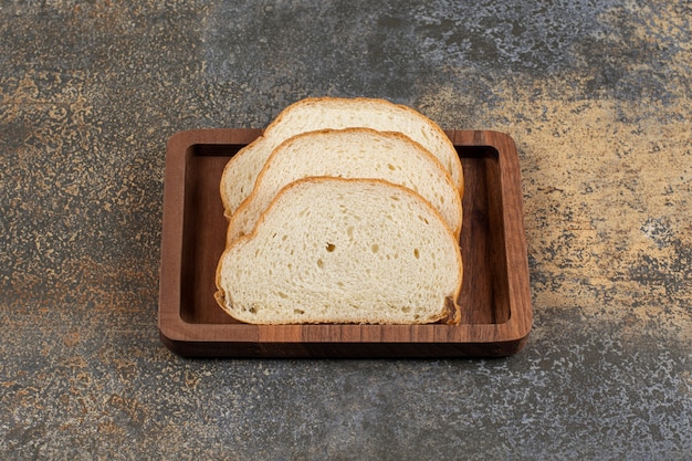 Leckere Weißbrotscheiben auf Holzteller