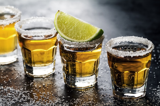 Leckerer Alkohol trinken Cocktail Tequila mit Kalk und Salz auf lebendigen dunklen Hintergrund. Nahansicht. Horizontal.