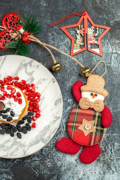 Leckerer cremiger Kuchen der Draufsicht mit Rosinen und Weihnachtsspielzeug auf hellem dunklem Hintergrund