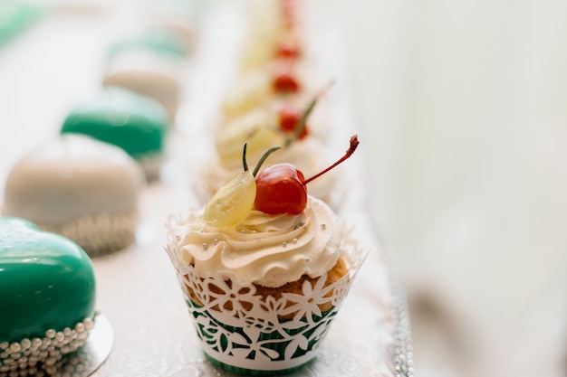 Leckerer Cupcake mit Sahne und Redberry auf dem Schokoriegel