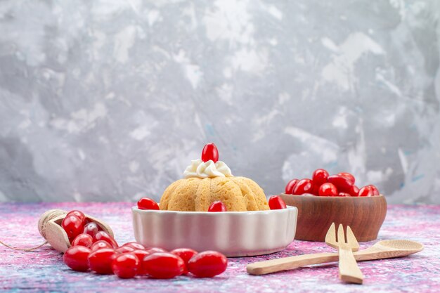 leckerer einfacher Kuchen mit Sahne und frischen Erdnüssen zusammen mit frischen roten Hartriegeln auf hellem hellem Schreibtisch, Kuchenkeks süße Nuss