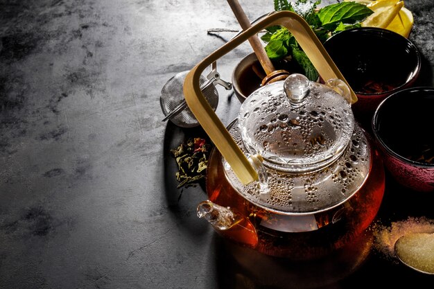 Leckerer frischer grüner Tee im Glas Teekanne-Zeremonie auf dunklem Hintergrund oben