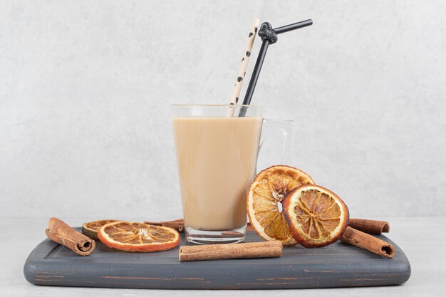 Leckerer Kaffee, Zimtstangen und Orangenscheiben auf dunklem Teller
