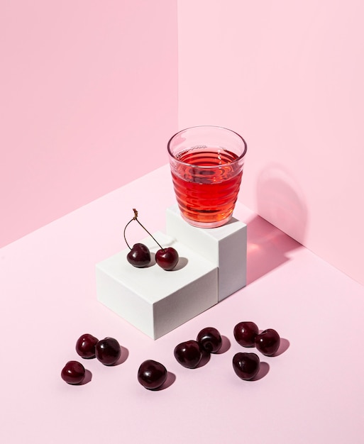 Leckerer Kirschsaft mit rosa Hintergrund