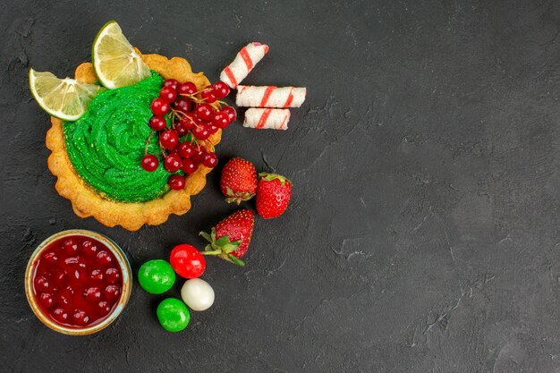 Leckerer Kuchen der Draufsicht mit Früchten auf Kekszucker des grauen Hintergrundplätzchens