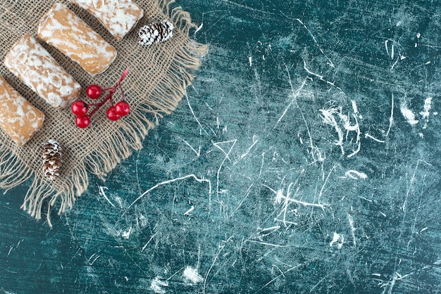 Kostenloses Foto leckerer lebkuchen mit tannenzapfen auf einem sackleinen. foto in hoher qualität