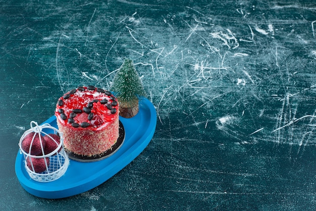 Leckerer Obstkuchen mit Weihnachtskugeln und Weihnachtsbaum. Foto in hoher Qualität