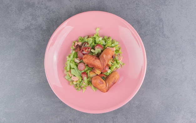 Leckerer Salat mit Wurst, auf der Marmoroberfläche