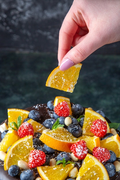 Kostenloses Foto leckerer schokoladenkuchen der vorderansicht mit frischen früchten auf dunkler wand