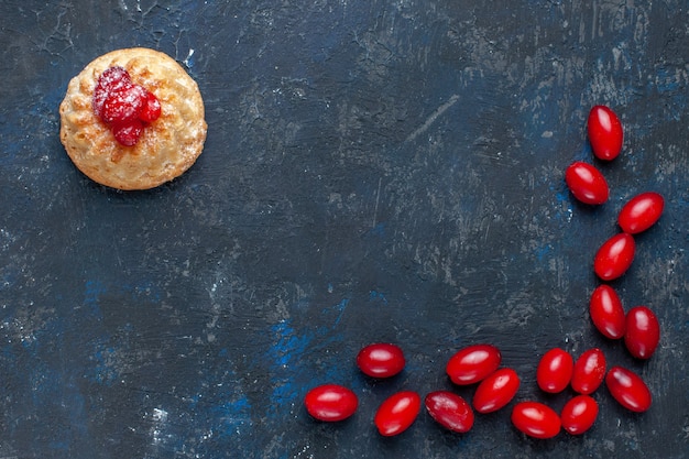 Leckerer süßer Kuchen von oben aus der Nähe mit roten Hartriegeln auf dunkelgrau