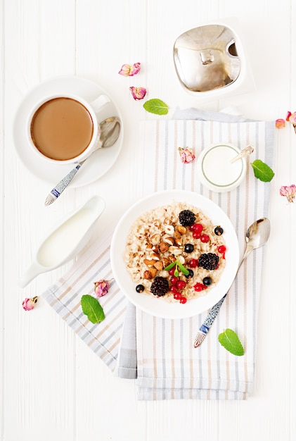 Leckerer und gesunder Haferbrei mit Beeren, Leinsamen und Nüssen. Gesundes Frühstück. Fitness Essen. Richtige Ernährung.