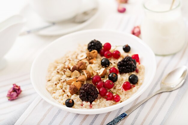 Leckerer und gesunder Haferbrei mit Beeren, Leinsamen und Nüssen. Gesundes Frühstück. Fitness Essen.