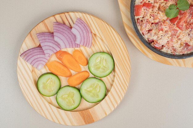 Leckeres Essen mit geschnittenem Gemüse auf Holzbrett.