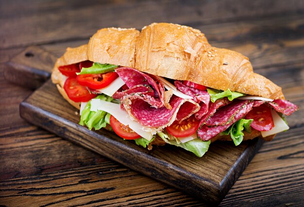 Leckeres Frühstück. Appetitlich Croissant mit Salami und, Käse und Tomaten