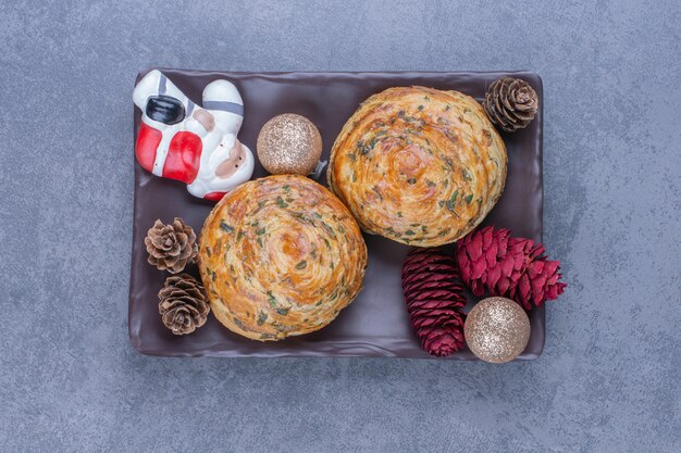 Leckeres Gebäck mit Weihnachtsspielzeug und Tannenzapfen