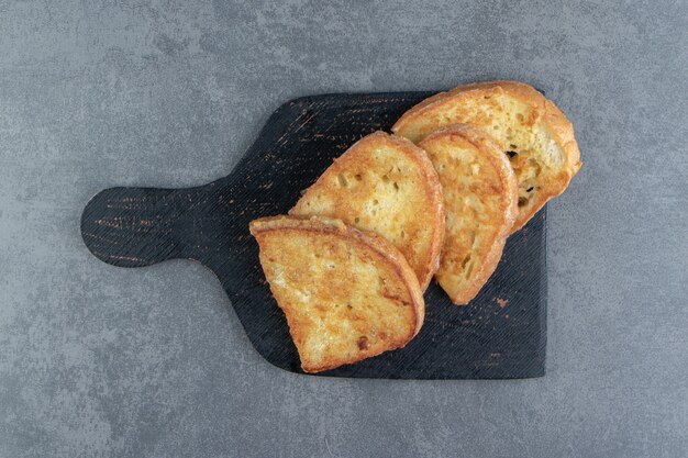 Leckeres gebratenes Brot mit Ei auf schwarzem Brett.