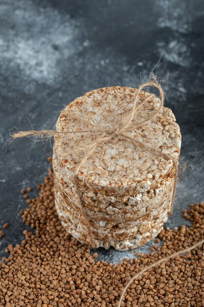 Leckeres Knäckebrot und roher Buchweizen auf Marmoroberfläche