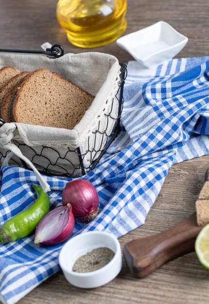 Leckeres Schwarzbrot mit Zwiebeln und Paprika auf Tischdecke