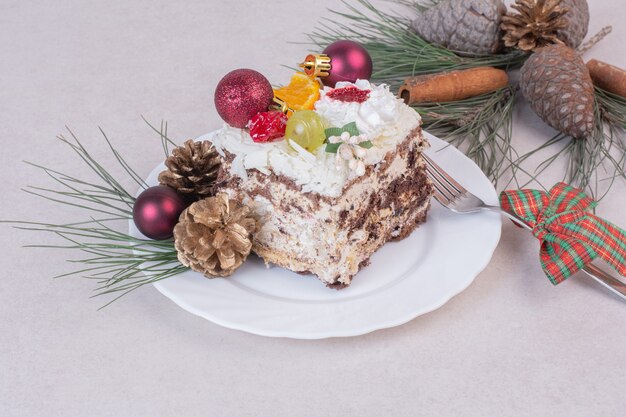 Leckeres Stück Kuchen mit Tannenzapfen und Ast des Baumes