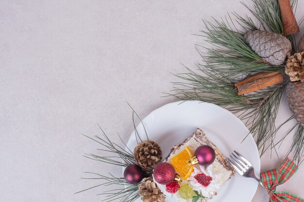 Leckeres Stück Kuchen mit Tannenzapfen und Ast des Baumes