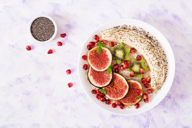 Leckeres und gesundes Haferflockenmehl mit Feigen, Kiwi, Granatapfel, Banane und Chiasamen. Gesundes Frühstück. Richtige Ernährung. Flach liegen. Draufsicht.