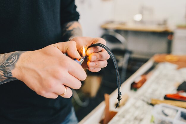 Lederhandwerker, der mit Leder unter Verwendung des Hammers arbeitet.