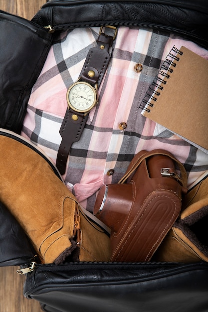 Ledertasche vollgepackt mit Schuhen und Kamera