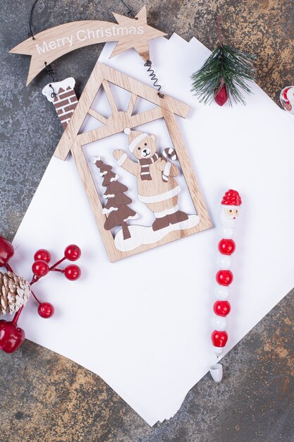 Leere Blätter mit Weihnachtsdekorationen auf Marmorfläche.