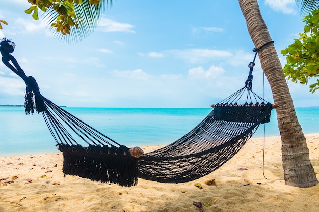 Kostenloses Foto leere hängematte schwingen um strandmeerozean mit weißem wolkenblauem himmel für reiseurlaub