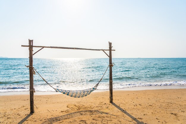 Leere Hängemattenschaukel auf dem schönen Strand und dem Meer