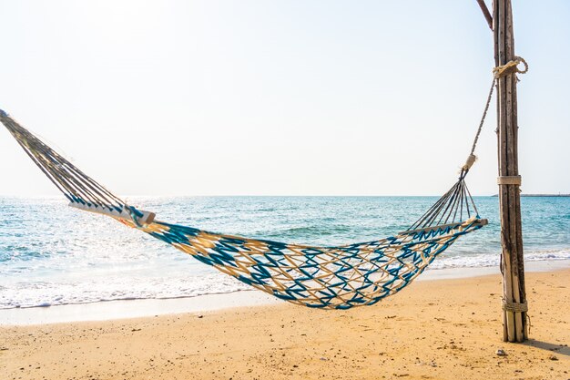 Leere Hängemattenschaukel auf dem schönen Strand und dem Meer