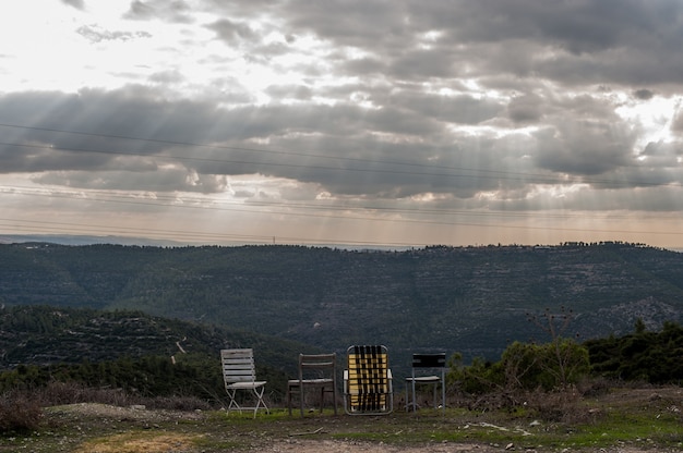 Leere Stühle in den Bergen unter dem dunklen bewölkten Himmel