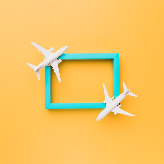 Leerer blauer Rahmen mit kleinen Flugzeugen
