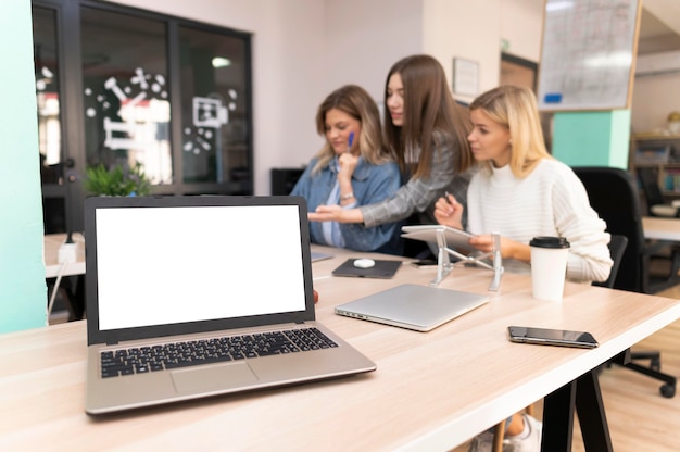 Kostenloses Foto leerer laptop neben kollegen