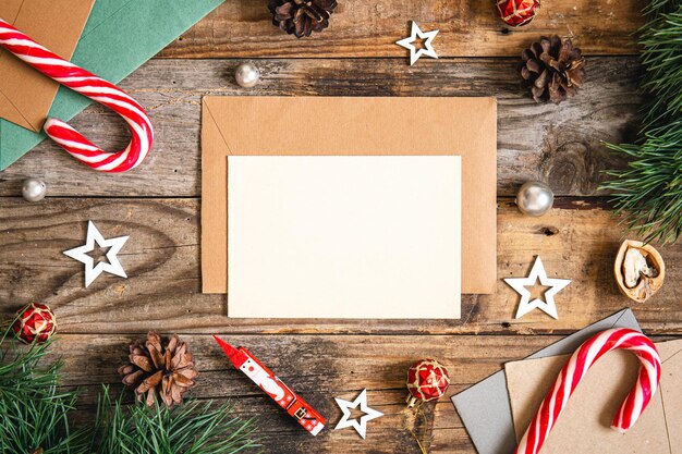 Leerer Papierumschlag und Weihnachtsdekor auf hölzernem Hintergrund kopieren Raum