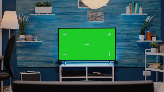 Leerer raum mit grünem bildschirm im fernsehen im wohnzimmer