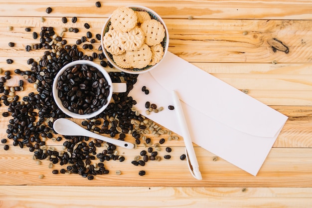 Leerer Umschlag nahe Plätzchen und Kaffeebohnen