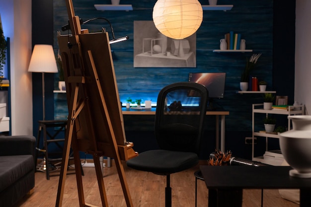 Leeres Kunststudio mit niemandem darin ist bereit für den Zeichenunterricht im Kunststudio. Modernes Atelier mit Vase auf Stuhl für Fantasie, professionelle Skizzenwerkzeuge auf dem Tisch. Konzept der Kreativität