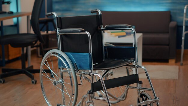 Leeres Wohnzimmer mit Rollstuhl für Menschen mit körperlicher Behinderung, die den Transport unterstützen. Niemand im Weltraum mit Mobilitäts- und Zugänglichkeitsausrüstung, um bei chronischen Problemen zu helfen.