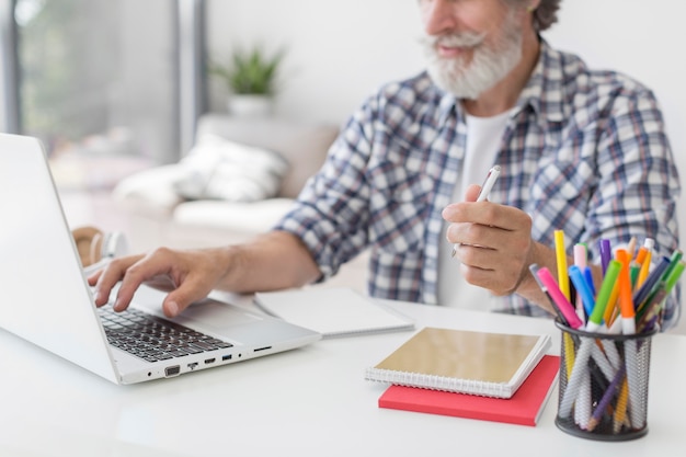 Lehrer hält Stift mit Laptop