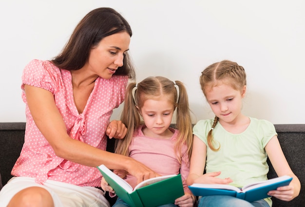 Lehrer hilft kleinen Mädchen beim Lesen einer neuen Lektion